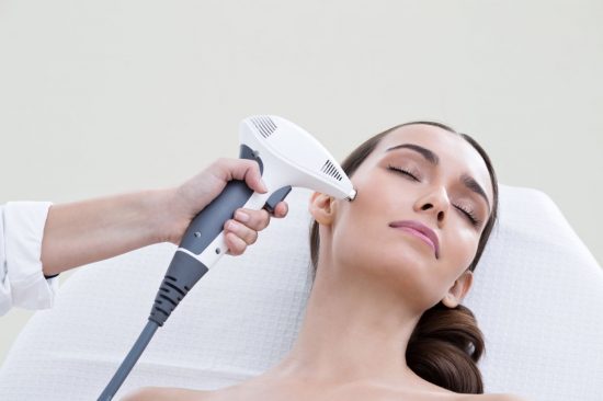 A woman getting her hair cut with an electric device.